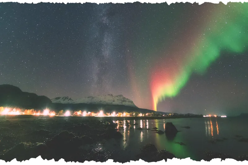 Aurora over the village lights across the water