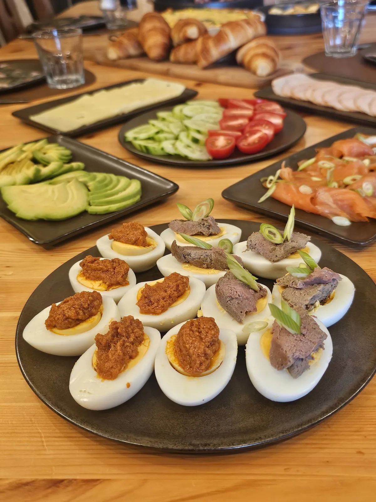 Devilled eggs, cheese, cured meats, vegetables and fresh bread on the table
