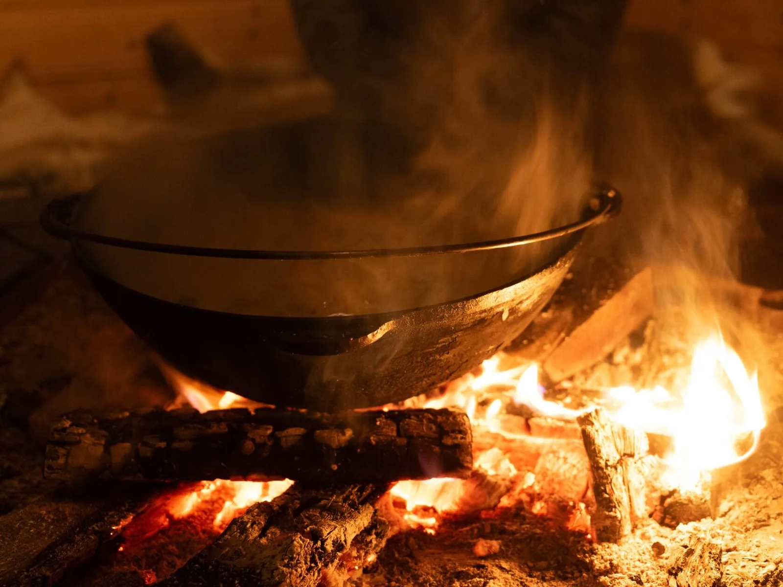 A meal cooking in a cauldron over the open fire
